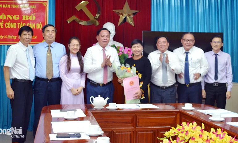 Quyền Chủ tịch Ủy ban nhân dân tỉnh Đồng Nai Võ Tấn Đức trao quyết định, tặng hoa chúc mừng tân Chủ tịch Hội đồng thành viên Dofico Đỗ Thị Thu Hằng. Ảnh: Báo Đồng Nai