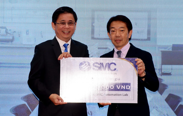 Tiến sĩ Lâm Thành Hiển (bên trái), Hiệu trưởng Trường đại học Lạc Hồng tiếp nhận bảng biểu trưng Phòng thí nghiệm trị giá hơn 6,5 tỷ đồng từ đại diện Tập đoàn SMC.