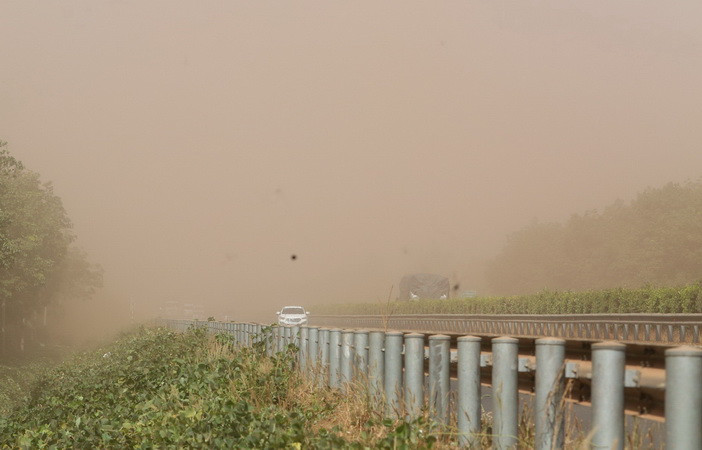 Phương tiện lưu thông trên đường cao tốc bị ảnh hưởng do bụi đỏ bao phủ.