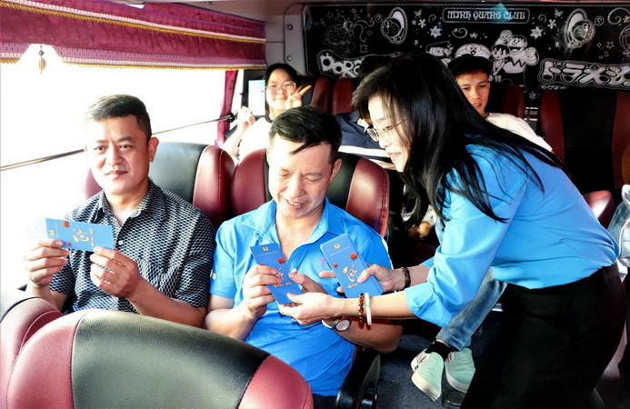 Phó Chủ tịch Thường trực Liên đoàn Lao động tỉnh Đồng Nai Bùi Thị Bích Thủy lì xì cho người lao động trên chuyến xe miễn phí về quê đón Tết.