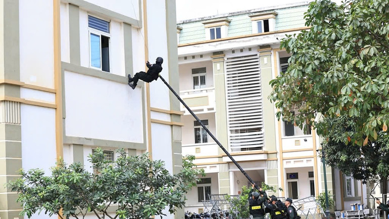 Diễn tập tình huống lực lượng đặc nhiệm thực hành trèo tường tiếp cận mục tiêu bằng sào.