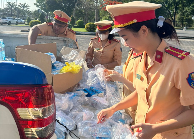 Các chiến sĩ Phòng Cảnh sát giao thông, Công an tỉnh Đồng Nai chuẩn bị nước suối, khăn lạnh để phát cho người dân.