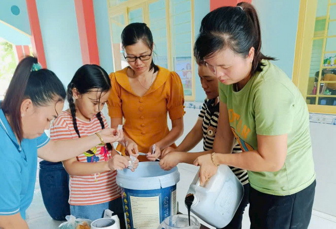 Giáo viên, nhân viên trường mầm non Thanh Bình đang chuẩn bị nguyên liệu để làm chế phẩm khử mùi hôi phòng vệ sinh.