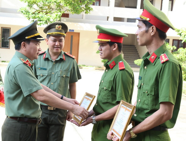 Thiếu tướng Nguyễn Sỹ Quang, Giám đốc Công an tỉnh Đồng Nai, trao giấy khen cho Đại úy Trương Ngũ Hổ và Hạ sỹ Dương Tuấn Kiệt.