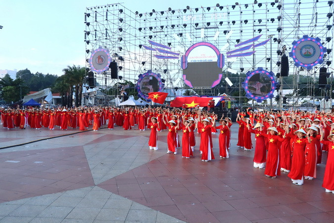 Trong trang phục áo dài cờ đỏ sao vàng hơn 1.000 người đồng diễn xếp hình nghệ thuật.