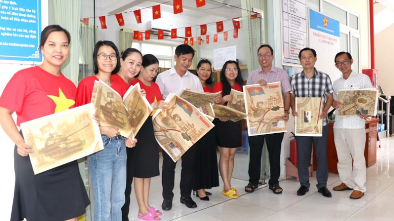 Cán bộ công nhân viên phường Quang Vinh hào hứng đón nhận phụ san đặc biệt Báo Nhân Dân.