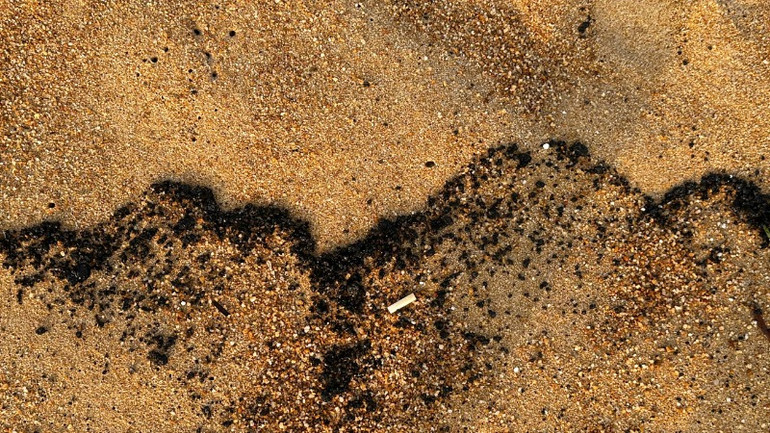 Hiện dầu vón cục vẫn tiếp tục trôi dạt vào bờ biển.