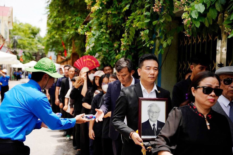 Thanh niên tình nguyện tiếp nước phục vụ người dân đến viếng Tổng Bí thư Nguyễn Phú Trọng tại quê hương Lại Đà, xã Đông Hội, huyện Đông Anh.