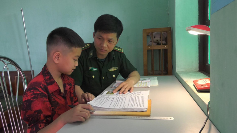 Cán bộ, chiến sĩ đồn biên phòng Chi Lăng, Lộc Bình, Lạng Sơn hướng dẫn con nuôi đồn biên phòng học bài.