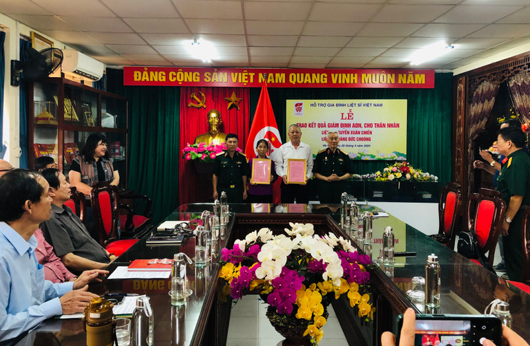 Trung tướng Lê Văn Hân (phải) và Trung tướng Trần Tấn Hùng (trái) trao kết quả giám định ADN cho thân nhân liệt sĩ.