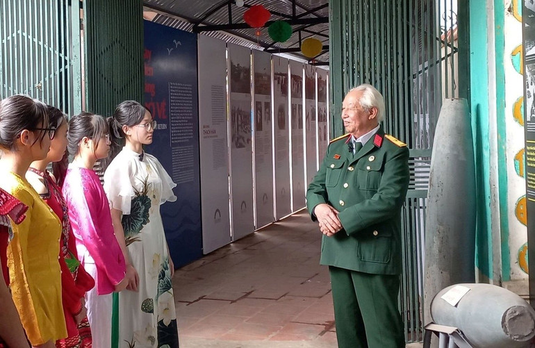 Ông Lâm Văn Bảng chia sẻ với các bạn trẻ về quá trình xây dựng bảo tàng. Ảnh: LƯU XA