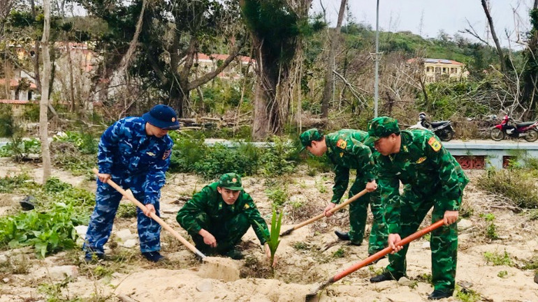 Các chiến sĩ lực lượng vũ trang tham gia trồng cây trên đảo tiền tiêu Bạch Long Vĩ. (Ảnh: SƠN HÀ)