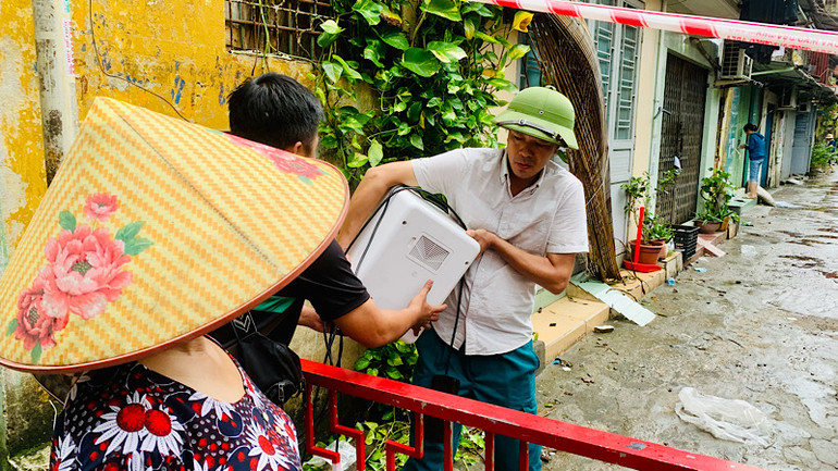 Cán bộ địa phương hỗ trợ người dân tại nhà A8 di chuyển đồ đạc nhỏ lẻ, thiết yếu.