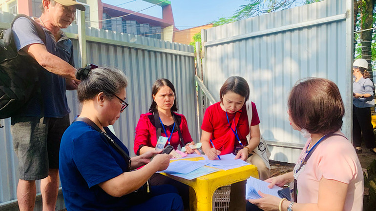 Các hộ dân xác nhận vị trí nhà ở cũ và nhận tiền hỗ trợ tự lo chỗ tạm cư.