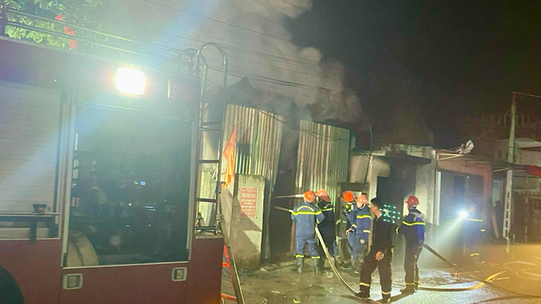 Các lực lượng chức năng phá cửa để chữa cháy.