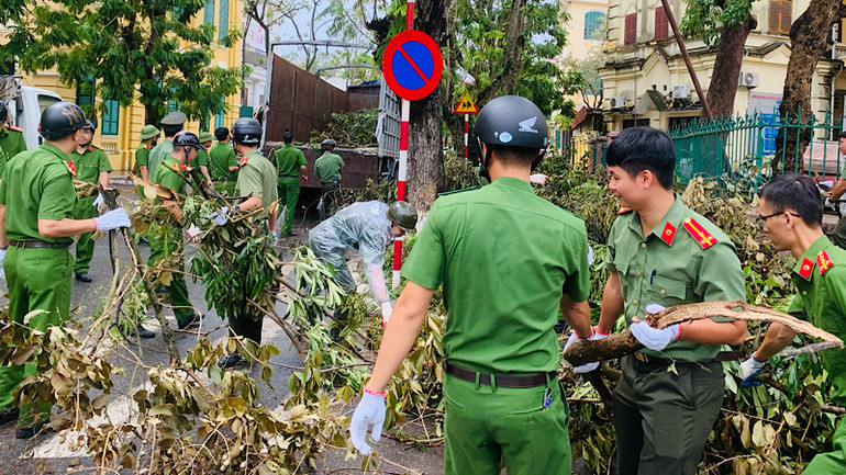 Lực lượng Công an thành phố Hải Phòng tham gia thu gom cành cây gãy đổ trên đường phố.