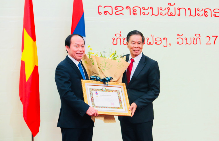 Đồng chí Sinlavong Khoutphaythoune trao Huân chương Itxala hạng II của Đảng, Nhà nước Cộng hòa dân chủ nhân dân Lào tặng đồng chí Lê Tiến Châu.