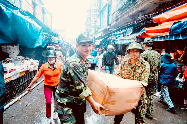 Các lực lượng tập trung hỗ trợ các hộ kinh doanh tại chợ Tam Bạc di chuyển hàng hóa khỏi vụ cháy.