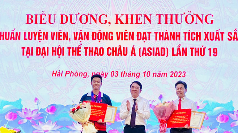 Vận động viên Phạm Quang Huy (bên trái) - người mang về tấm Huy chương Vàng lịch sử cho bắn súng Việt Nam tại ASIAD 19 được lãnh đạo thành phố Hải Phòng biểu dương, khen thưởng.
