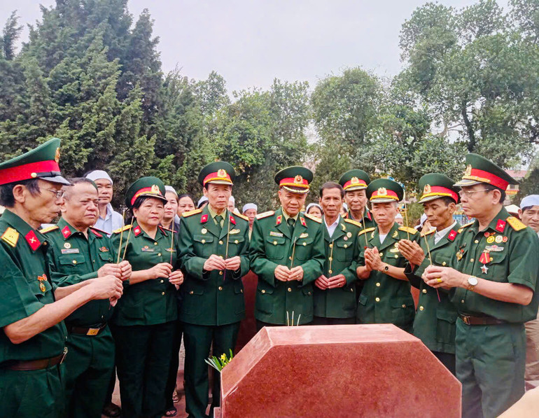 Trung tướng Hoàng Khánh Hưng (đứng giữa) cùng các hội viên Hội hỗ trợ gia đình liệt sĩ Việt Nam thăm viếng mộ liệt sĩ.