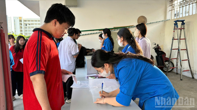 Đoàn viên hỗ trợ thí sinh làm thủ tục gửi đồ trước khi vào phòng thi. ndo_br_z6660302229833-5e0d0ae8cc13053608b992870a65313d-9072.jpg