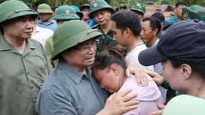 Thủ tướng chia sẻ với nỗi đau mất người thân của người dân vùng lũ quét. (Ảnh TTXVN)