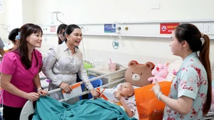 Đại diện Ban Tổ chức thăm hỏi và tặng quà cho bệnh nhi. (Ảnh NFVC)
