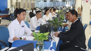 Cán bộ tại bộ phận một cửa Ủy ban nhân dân tỉnh Quảng Ngãi tiếp đón và giải quyết hồ sơ cho người dân. (Ảnh: HIỂN CỪ)