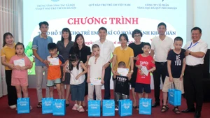 Các đại biểu trao hỗ trợ cho trẻ tự kỷ có hoàn cảnh khó khăn tại Hà Nội. (Ảnh NFVC)