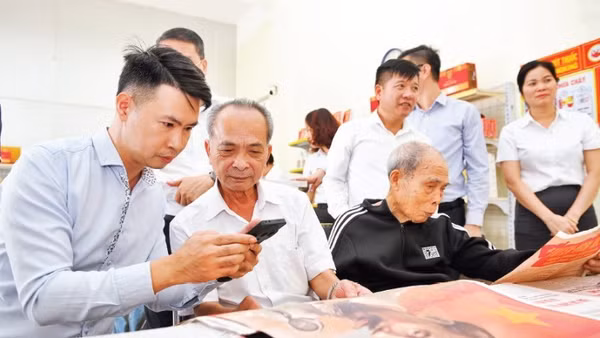 Người dân tìm hiểu phụ trương dự thảo các văn kiện trình đại hội XIV của Đảng tại điểm bưu điện văn hóa xã Dạ Trạch, tỉnh Hưng Yên. (Ảnh: THẾ ĐẠI)