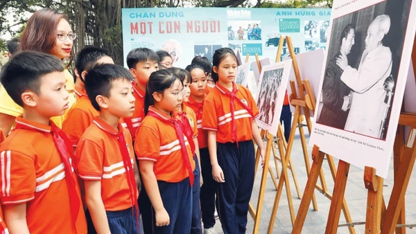 Học sinh tham quan triển lãm ảnh “Rạng rỡ tên Người” nhân dịp kỷ niệm 135 năm Ngày sinh Chủ tịch Hồ Chí Minh do Báo Nhân Dân tổ chức. (Ảnh: KHIẾU MINH)