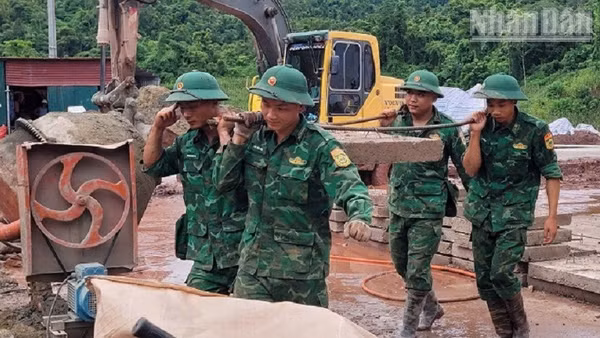 Cán bộ, chiến sĩ Bộ đội Biên phòng Điện Biên chung sức vận chuyển vật liệu phục vụ thi công xây dựng Trường nội trú liên cấp Sín Thầu. 