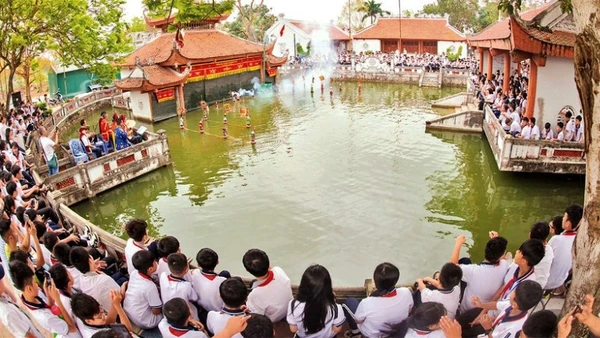 Các em học sinh xem trình diễn rối nước ở làng Thư Lâm, thành phố Hà Nội. (Ảnh: Báo Nhân Dân)