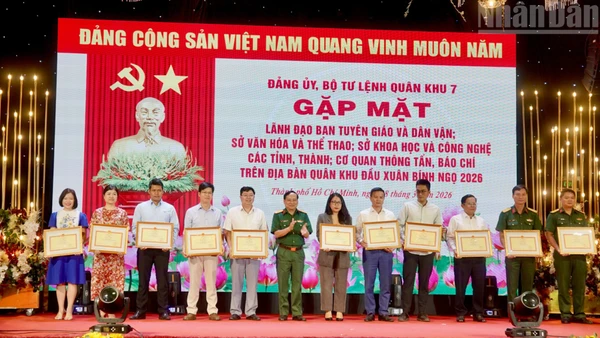 Đại diện Báo Nhân Dân tại khu vực miền Nam (thứ tư từ trái sang) nhận bằng khen từ Bộ Tư lệnh Quân khu 7. 