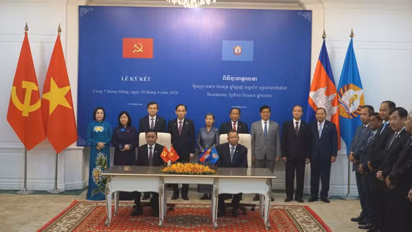 Thường trực Ban Bí thư Trần Cẩm Tú và Phó Chủ tịch Đảng Nhân dân Campuchia, Trưởng Ban Thường trực Ban Thường vụ Đảng Nhân dân Campuchia Say Chhum chứng kiến lễ trao các văn kiện hợp tác. (Ảnh: ĐINH TRƯỜNG) 