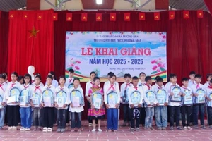 Cán bộ Đồn Biên phòng Cửa khẩu Huổi Puốc và Mường Nhà tặng quà tặng học sinh trong Dự án “Cán bộ, chiến sĩ Quân đội nâng bước em tới trường”. (Ảnh: ANH DŨNG)