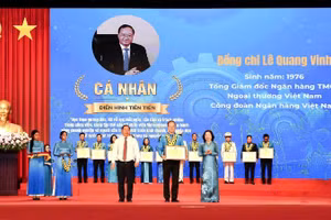 Đồng chí Nguyễn Phi Long, Ủy viên Trung ương Đảng, Phó Bí thư Thường trực Đảng ủy Mặt trận Tổ quốc các đoàn thể Trung ương, Phó Chủ tịch Ủy ban Trung ương Mặt trận Tổ quốc Việt Nam (bên trái) trao hoa chúc mừng và đồng chí Thái Thu Sương, Phó Chủ tịch thường trực Tổng Liên đoàn Lao động Việt Nam (bên phải) trao bằng khen cho đồng chí Lê Quang Vinh.