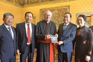 Chủ tịch Quốc hội Trần Thanh Mẫn và Phu nhân chụp ảnh chung với Thủ tướng Tòa thánh Vatican, Hồng y Pietro Parolin và trao đổi tặng phẩm. (Ảnh: TTXVN)