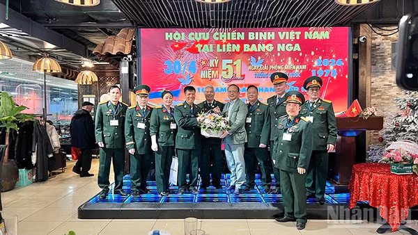 Chủ tịch Liên hiệp các tổ chức người Việt Nam tại Liên bang Nga Đỗ Xuân Hoàng tặng hoa chúc mừng Hội Cựu chiến binh Việt Nam tại Liên bang Nga. (Ảnh: XUÂN HƯNG)