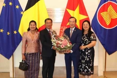 Đại sứ Kingphokeo Phommahaxay (trái) tặng hoa cho Đại sứ Nguyễn Văn Thảo. (Ảnh: HƯƠNG GIANG/TTXVN)