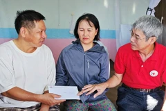 Đại diện Hội chữ thập tỉnh Thanh Hóa trao khoản hỗ trợ của Trung ương hội Chữ thập đỏ cho người bị thương do bão số 10 ở Thanh Hóa.