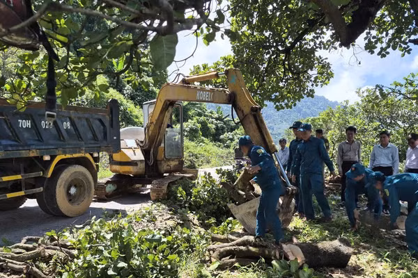 Lực lượng chức năng hỗ trợ người dân bàn giao mặt bằng đèo Tà Pứa. (Ảnh: ĐỨC LINH)