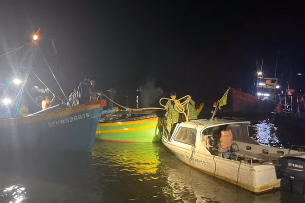 Các lực lượng biên phòng đang lai dắt tàu cá vào bờ. (Ảnh: Bộ đội Biên phòng cung cấp)
