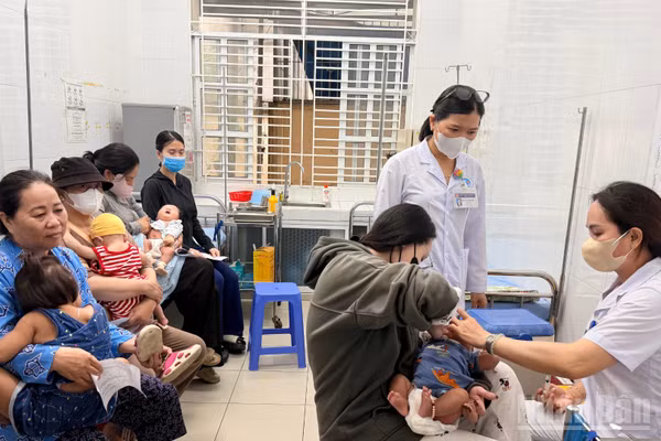 Phụ huynh đưa trẻ đi tiêm chủng tại Trạm y tế phường Phan Thiết.