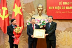 Bí thư Đảng ủy Quốc hội, Chủ tịch Quốc hội Trần Thanh Mẫn trao Huy hiệu 30 năm tuổi đảng cho đồng chí Vũ Hải Hà. (Ảnh DUY LINH)
