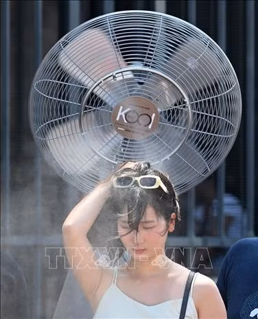 Khách du lịch làm mát khi nắng nóng bao trùm thủ đô Rome của Italia, ngày 26/6/2025. (Ảnh: THX/TTXVN)