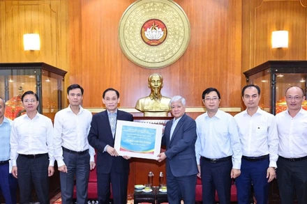 Đồng chí Đỗ Văn Chiến (thứ 4 từ phải sang) tiếp nhận kinh phí ủng hộ từ đồng chí Lê Hoài Trung. 