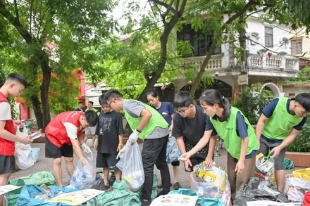 Các thành viên nhóm Tagom ở Hà Nội hướng dẫn người dân cách phân loại rác. (Ảnh: THẾ ĐẠI)