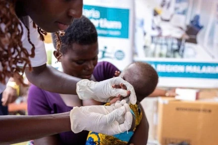 Nhân viên y tế tiêm vaccine sốt rét cho trẻ ở Uganda.