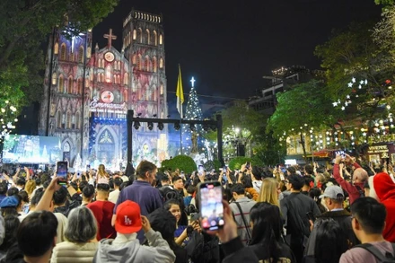 Đông đảo người dân và du khách đổ về Nhà thờ Lớn Hà Nội trong đêm Giáng sinh. (Ảnh THẾ ĐẠI)